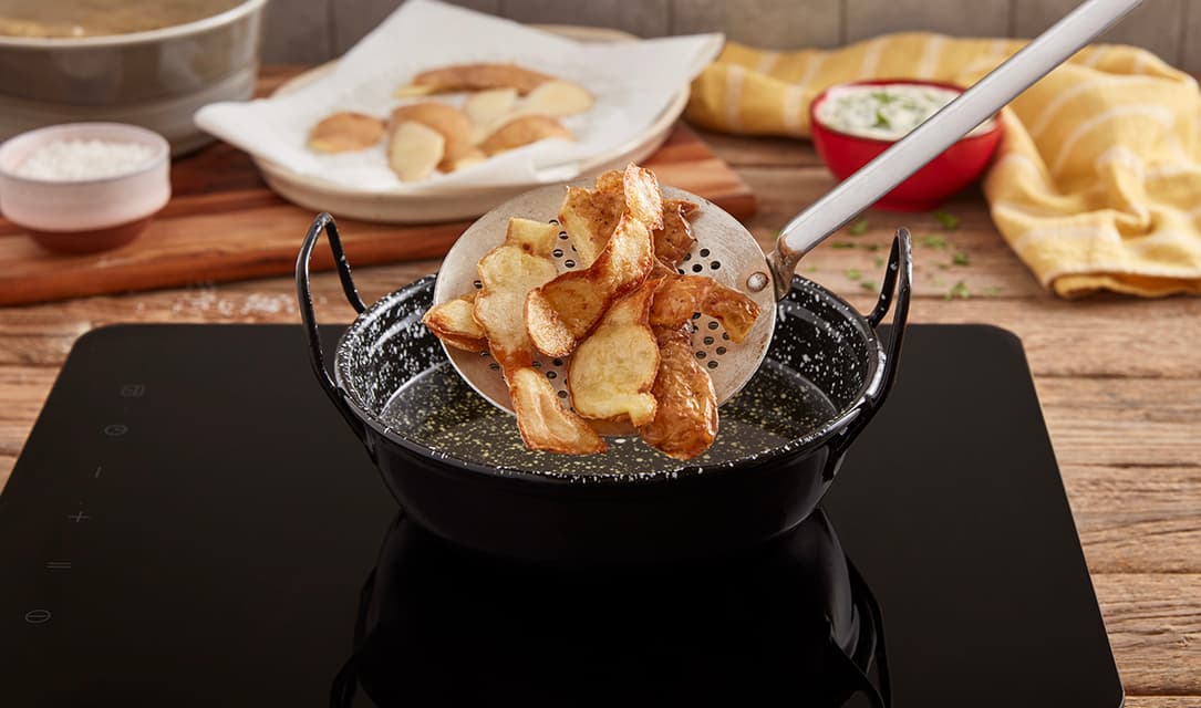 Lascas de batata a fritar em óleo Fula