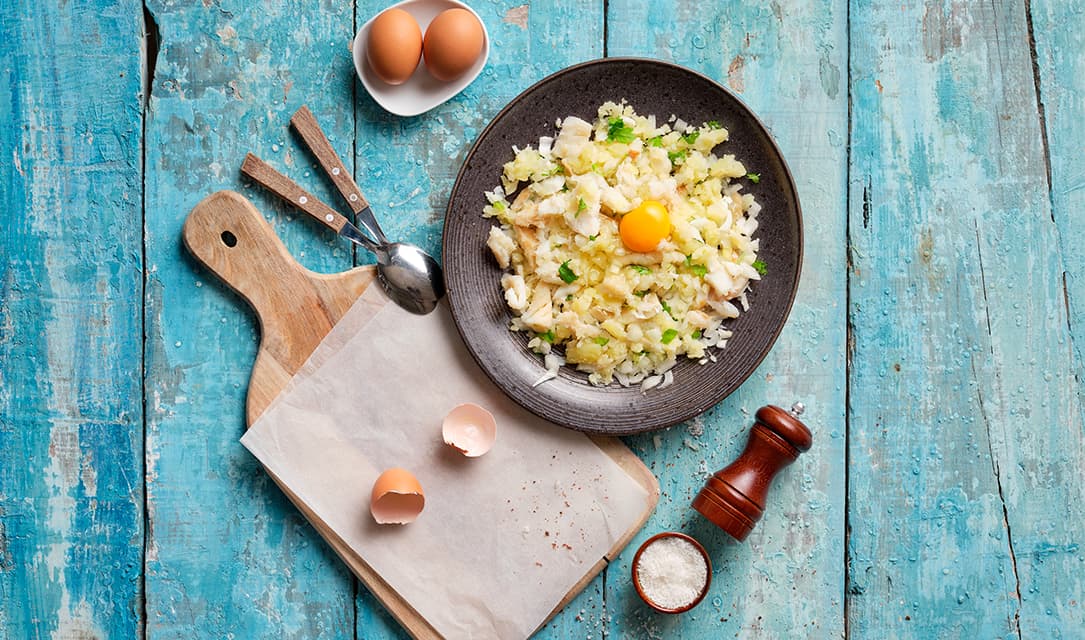Juntar ovos ao bacalhau para fazer pastéis de bacalhau