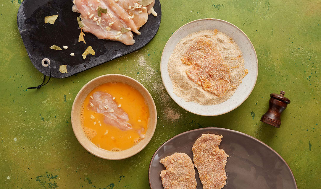 Bifes de frango em ovo e pão ralado para fritar