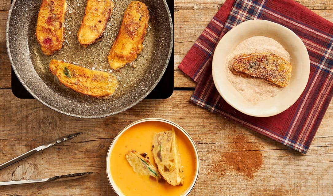 Fatias de bolo rei mergulhadas em ovo batido e a fritar em óleo Fula