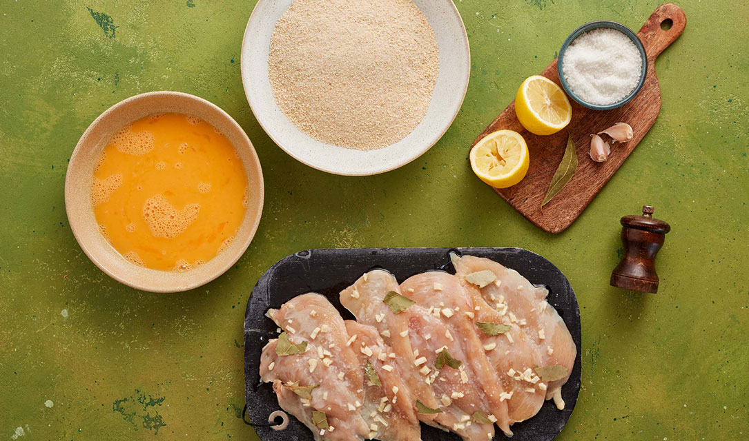 Bifes de frango temperados e ingredientes para panar