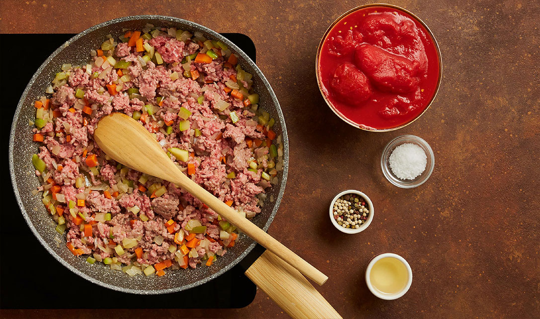 Carne na frigideira com ingredientes para molho bolonhesa